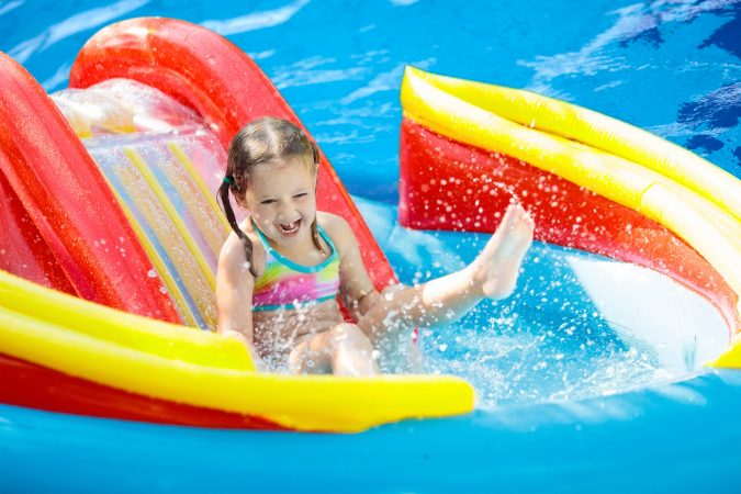 Child on water slide in pool