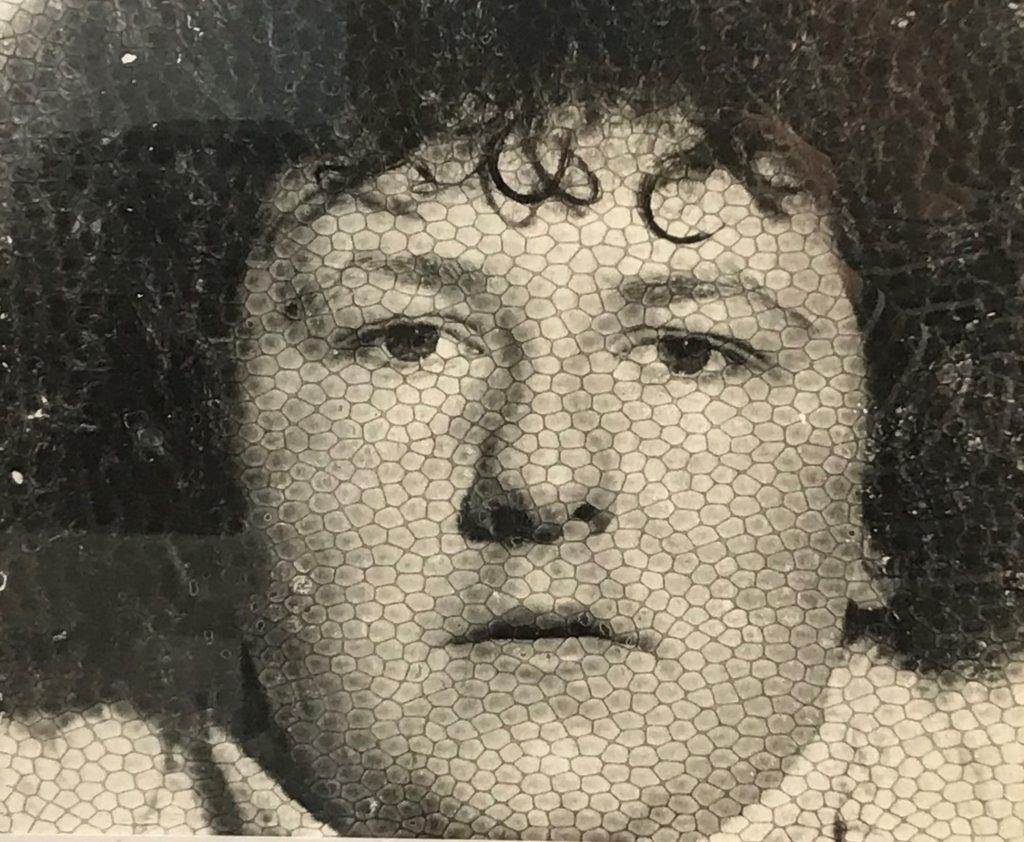 What's Changed? 6. Photo of person looking through wire mesh, date unknown